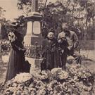 Three mourners at a graveside